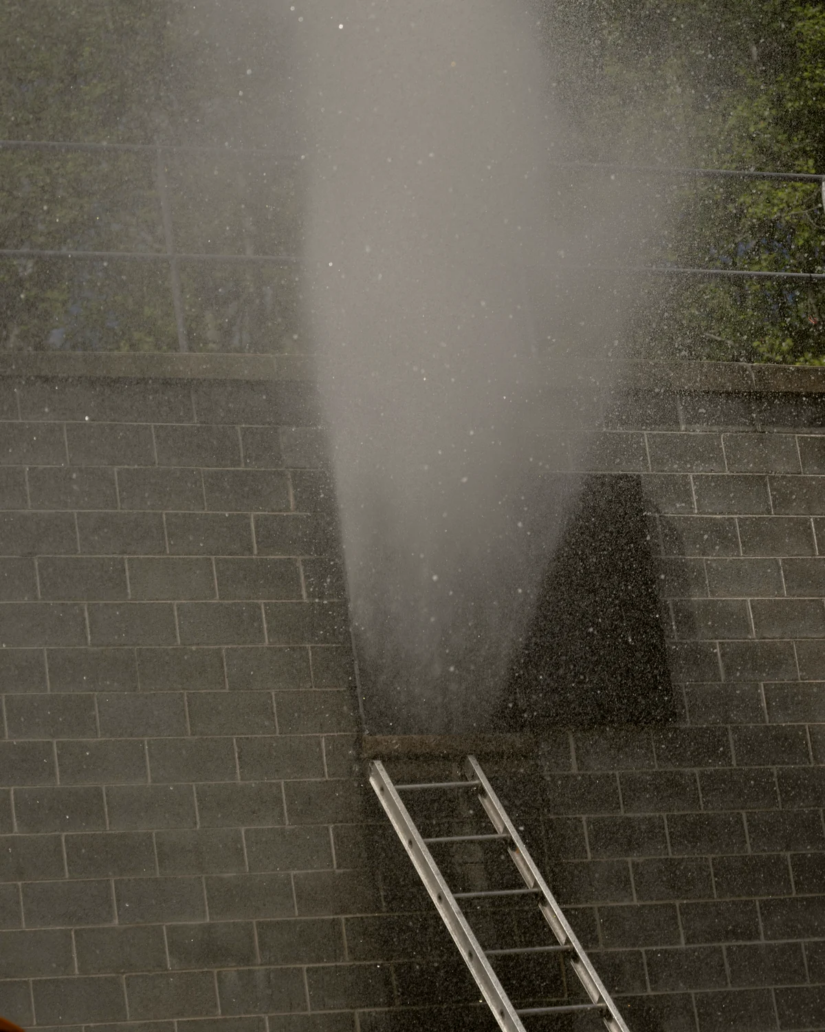 Colonne de brume d'une laveuse à pression contre un mur de blocs : photo d'illustration